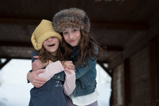 Girls hugging under a bridge in the winter