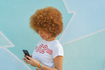 woman with afro hair using her smartphone