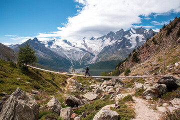 Fototapeta na wymiar one person young man walking on a suspension bridge in Switzerland, hiking with a beautiful landscape