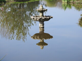 A small fountain and its reflection in the water
