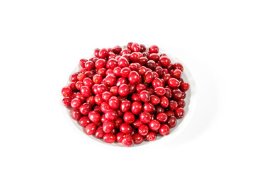 Red cherries on a white plate on a white background