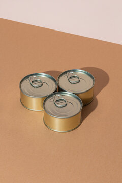 Set of tins with canned food on brown surface