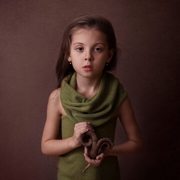a girl on a brown background holds a palm leaf signifying the zodiac s
