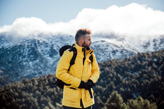 Young man with yellow jacket and backpack in the mountains.