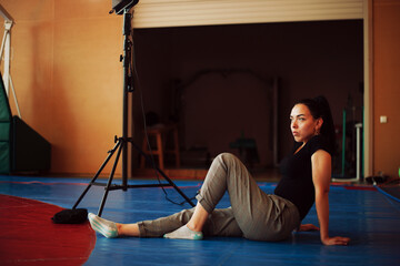 Charming brunette sits near luminaire on tatami
