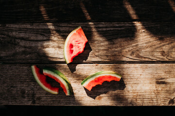 Watermelon with bites taken sitting on picnic table in bright light