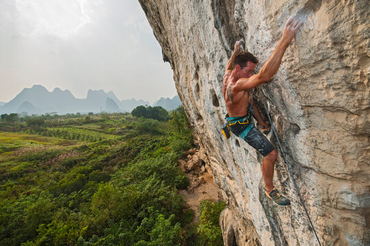 Man climbing on rock in Yangshuo, China