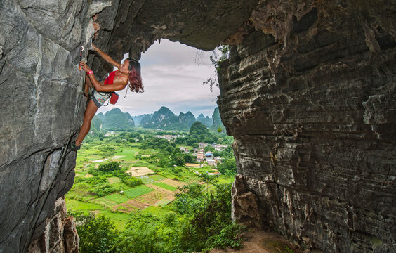 young female climber climbing at treasure cave in Yangshuo, China