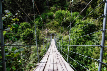 Fototapeta na wymiar wooden suspension bridge in the forest beautiful mountain landscape