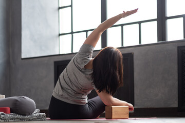 Caucasian woman doing stretching yoga exercise yoga side bend at home