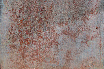 The surface of the old steel sheet is coated with a light blue paint. Corrosion points show through the paint layer. Background. Texture.