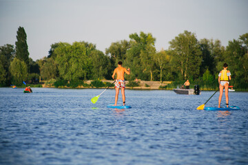 Young beautiful woman in a bikini on a SUP board in the river