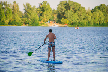 Young beautiful woman in a bikini on a SUP board in the river