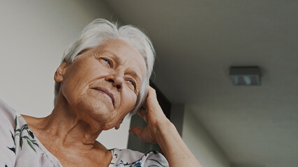 Portrait of senior gray haired woman looking in the distance. Low angle shot. High quality photo