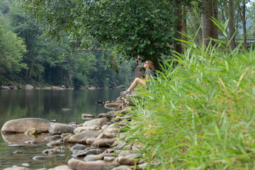 Mujer mirando el rio entre la naturaleza