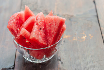 slices of sweet juicy watermelon in a glass bowl on a wooden table