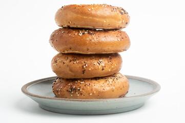 A Stack Of Four "Everything" Bagels On Ceramic Breakfast Plate