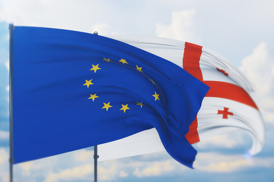 Waving European Union flag and flag of Georgia. Closeup view, 3D illustration.