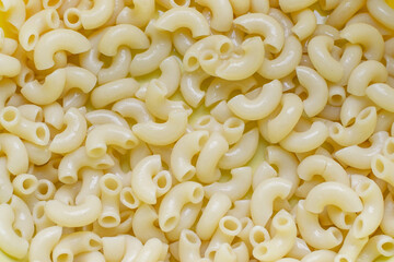 boiled pasta horns close up, yellow background