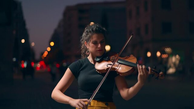 mujer tocando el violin de noche