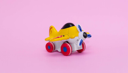 Toy plane in yellow on pink background