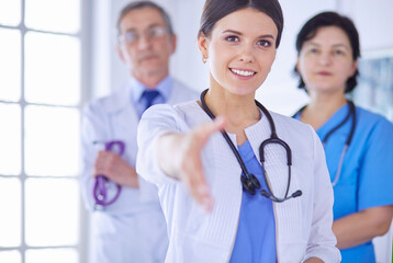 Female doctor offering a handshake in the hospital