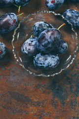 Ripe plums on a glass plate, with a copy space