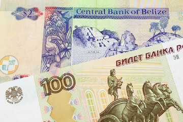 A macro image of a Russian one hundred ruble note paired up with a colorful two dollar bill from Belize.  Shot close up in macro.