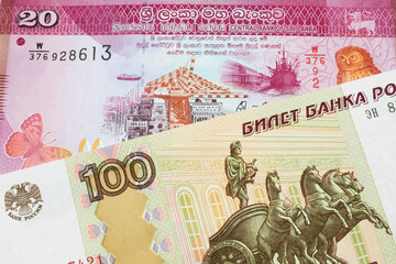 A macro image of a Russian one hundred ruble note paired up with a pink and white twenty rupee bank...