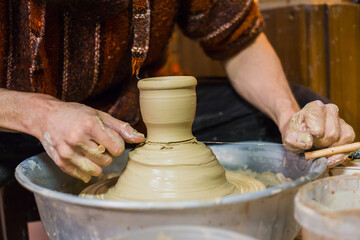 Professional male potter working in workshop, studio. Handmade, small business, traditional, manufacturing, art and handicraft concept