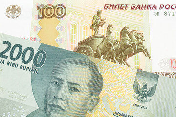 A macro image of a Russian one hundred ruble note paired up with a grey two thousand rupiah bank note from Indonesia.  Shot close up in macro.