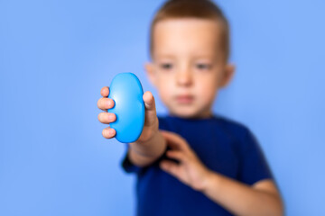 Baby holds soap, focus on soap