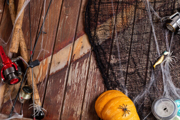 Fishing tacles on wooden background in Halloween designe with spaders and web