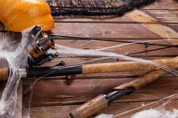 Fishing tacles on wooden background in Halloween designe with spaders and web