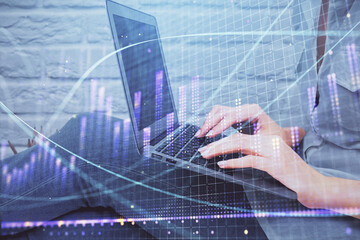 Multi exposure of woman hands typing on computer and forex chart hologram drawing. Stock market analysis concept.