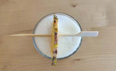 Top view of fresh pineapple smoothie glass on wood table - Healthy Drink.