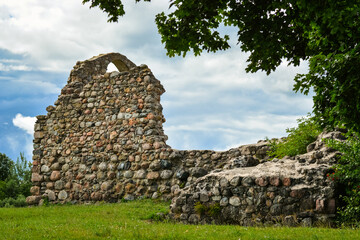 Old historic stone ruins of an ancient castle with a cloudy sky behind. Rezekne, Latvia.