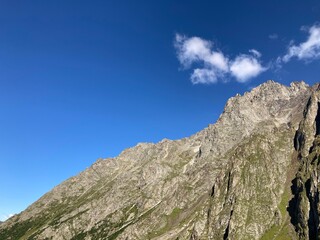 Mountain peaks against cloudy sky. Peaks of magnificent rocks located against bright cloudy sky on sunny day in nature.