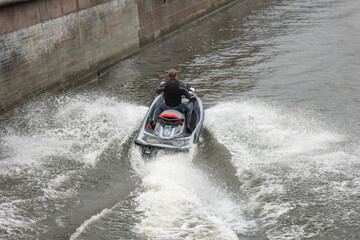 Fototapeta premium man cuts waves on a jet ski extreme speed splash