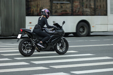 attractive woman biker on a motorcycle rides around the city speed