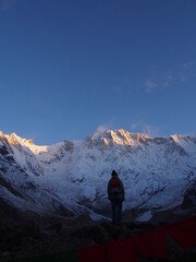 A mountain climber gaze across Talcho (Tibetan praying flags) at the snow-covered Himalayas in the...