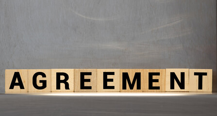 AGREEMENT word on wooden cubes on gray background