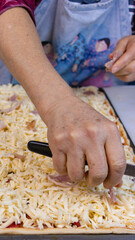elderly woman white mother cutting sausages and sausages to make pizza