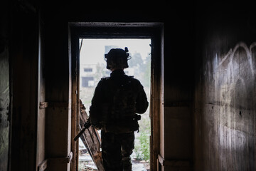 Front view close up of caucasian soldier with a rifle stand guard securing territory looking around.