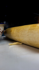 roller about to crush a small piece of dough to make bread