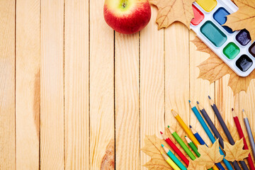 back to school concept. education and study stationery on a wooden desk. above view. decorated with yellow maple leaves