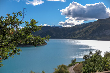 Lake of Castillion with blue melting water with surrounding forest mountains, commune of...