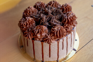 Exquisite chocolate cake with chocolate cream and brownies on top.