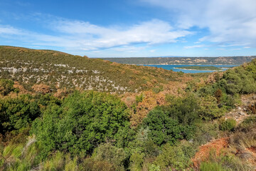 Fototapeta na wymiar Lake of Sainte-Croix with blue melting water with forest mountains around, commune of Les Salles-sur-Verdon, region of Provence-Alpes-Côte d'Azur, Alpes de Haute Provence, France