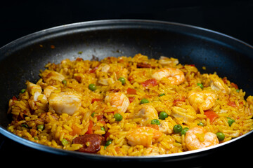 Sea Food Home made Paella Valenciana. Typical Spanish seafood paella in traditional pan. Macro close-up. Selective focus